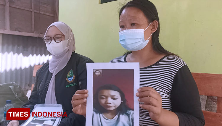 Marni saat menunjukkan potret anaknya yang dibawa ke Papua. (Foto: Muhamad Jupri/TIMES Indonesia)
