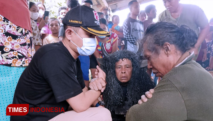 Kepala Desa Aliyan Banyuwangi, Anton Sujarwo bersama pawang Keboan berusaha menyadarkan warga yang kesurupan. (FOTO: Agung Sedana/ TIMES Indonesia)