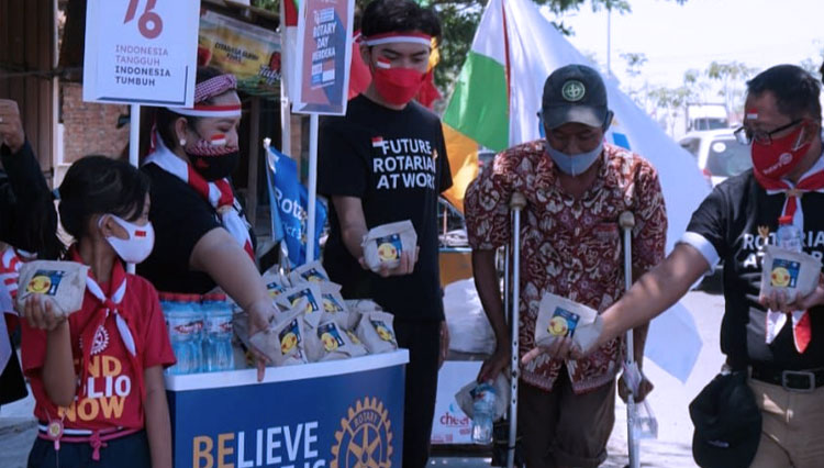 Foto : Aksi Rotary Club Surabaja-Darmo bersama Rotaract Club Surabaya Darmo Raya berbagi nasi bungkus kepada warga pada Minggu (15/8/2021) kemarin. (FOTO: Dok.Rotary)