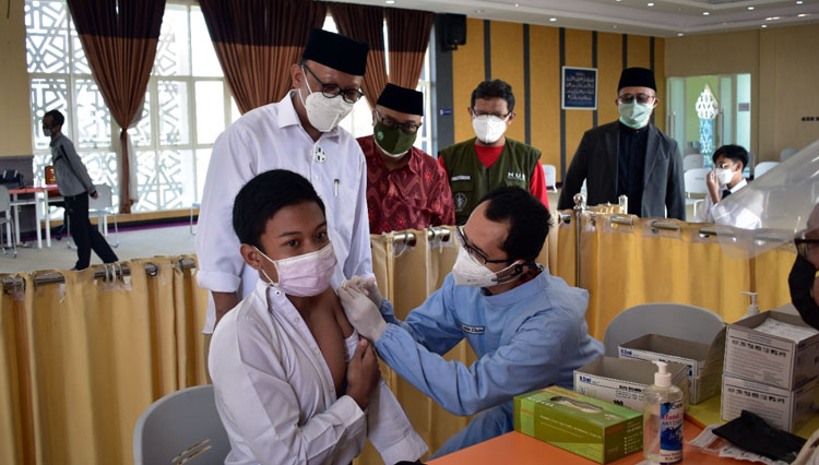 Santri Thursina IIBS Malang saat mengikuti vaksinasi Covid-19. Rektor Unisma bersama pejabat lainnya melakukan pemantauan. (Foto: Humas Unisma)