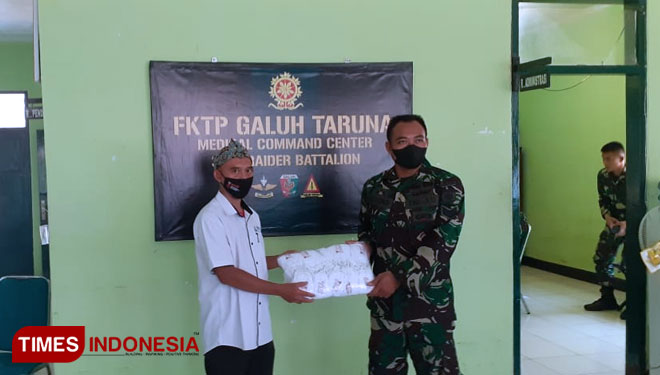 Ketua Pemuda Muhammadiyah Majalengka Defri Ardiansyah secara simbolis memberikan masker kepada Yonif Raider 321 Galuh Taruna. (Foto: Jaja Sumarja/TIMES Indonesia)