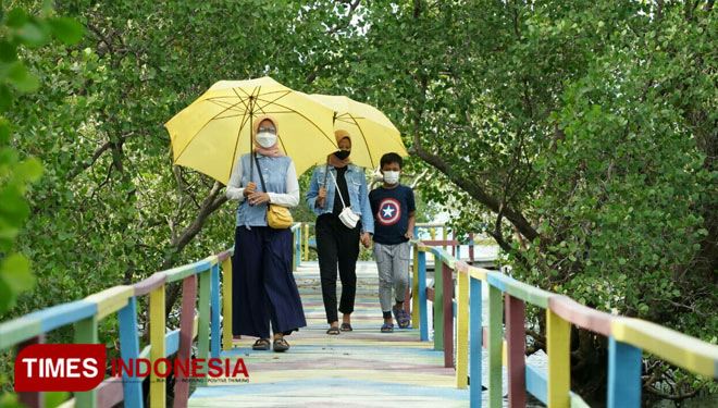 Wisatawan tengah menyusuri dan menikmati suasana hutan mangrove di Desa Labuhan, Kecamatan Sepulu, Kabupaten Bangkalan. (FOTO: Doni Heriyanto/TIMES Indonesia)