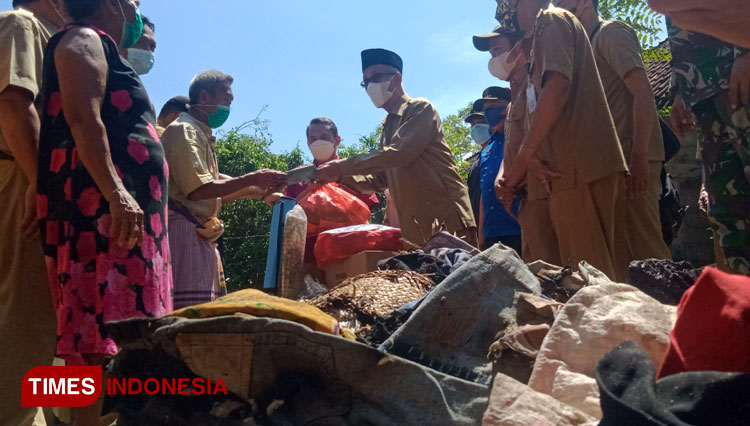 Bupati Bondowoso KH Salwa Arifin saat memberikan langsung bantuan. Pemkab juga akan segera bangun rumah korban (FOTO: Moh Bahri/TIMES Indonesia).