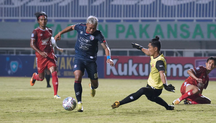 Pemain Arema FC Kushedya Hari Yudho berusaha melewati kiper PSM Hilman Syah (Foto: Media Officer Arema FC)