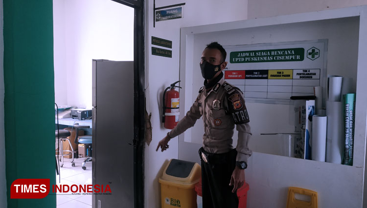 Seorang anggota Polsek Jatinangor saat menunjukan ruangan yang berhasil dibongkar pencuri di UPTD Puskesmas Cisempur (FOTO: Alan Dahlan/TIMES Indonesia)
