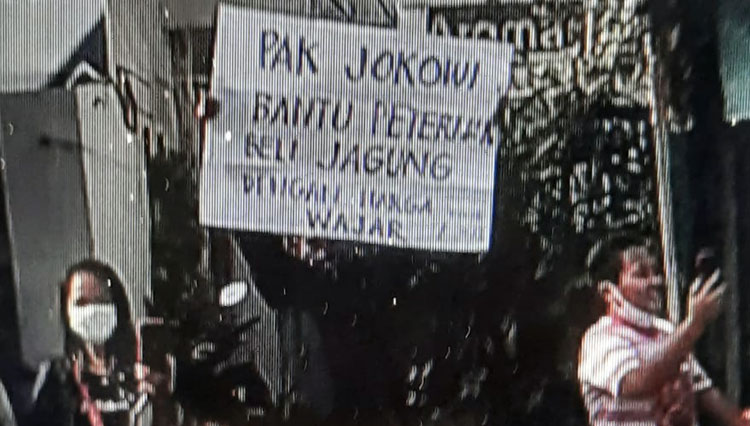 Tangkapan layar video seorang pria membentangkan poster saat kunjungan Presiden Jokowi ke Kota Blitar, Selasa (7/9/2021). (Foto: Istimewa) 
