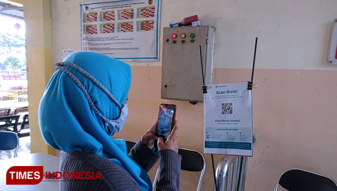 Calon penumpang bus saat melakukan scan aplikasi Peduli Lindungi di Terminal Kertonegoro Ngawi. (Foto: M.Miftakul/TIMES Indonesia)
