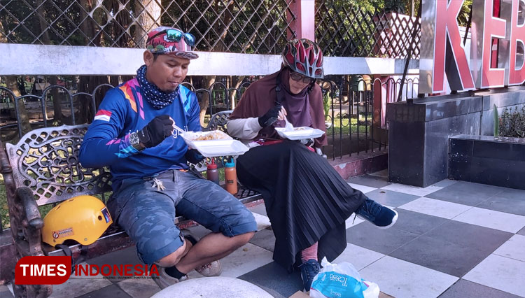 Seorang pelanggan sedang menikmati Bubur Ayam Tasik di depan Taman Kebon Rojo Kota Blitar, Kamis (9/9/2021). (FOTO: Sholeh/ TIMES Indonesia)