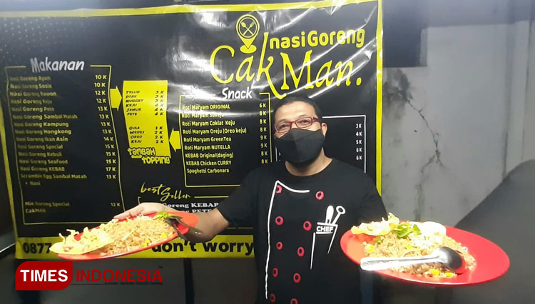 Cak Man, the owner of Nasi Goreng Cak Man Madiun presents his two main signature dishes. (Photo: Bambang H Irwanto/TIMES Indonesia)