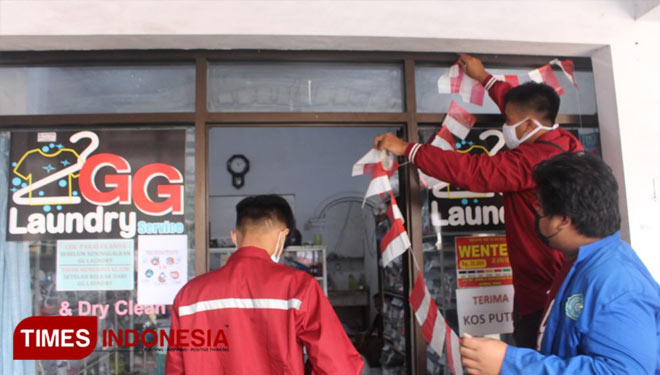 Mahasiswa UM Jember mempercantik tempat usaha laundry saat KKN. (Foto: Humas UM Jember for TIMES Indonesia)