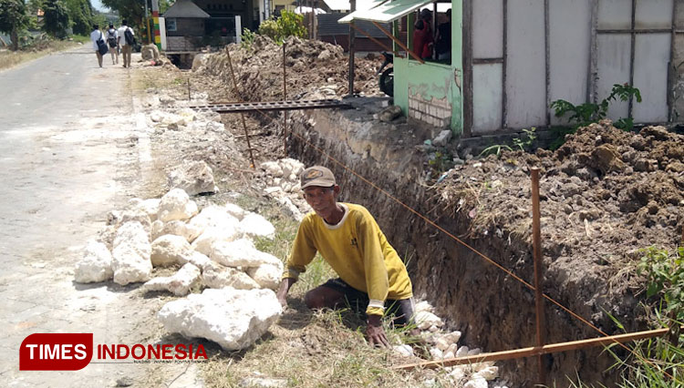 Salah seorang pekerja saat mengerjakan proyek irigasi di Desa Ima'an Dukun (Foto: Akmal/TIMES Indonesia).