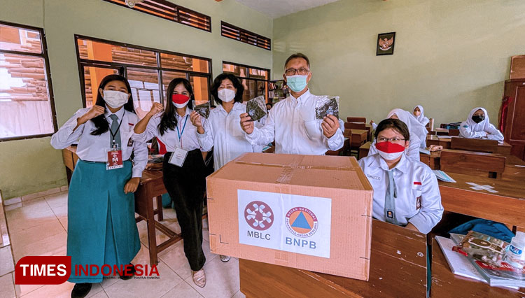 Relawan MBLC menyerahkan bantuan masker gratis dari BNPB kepada siswa dan guru di lingkungan SMAN 1 Lawang. (Foto: MBLC/TIMES Indonesia)