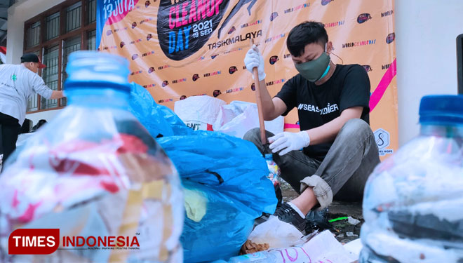 Seorang relawan memilah sampah plastik hasil aksi Word Celanup Day untuk selanjutnya akan dikumpulkan dan dimanfaatkan pada program Bank Sampah, Minggu, (19/9/2021) siang. (FOTO: Harniwan Obech/TIMES Indonesia)
