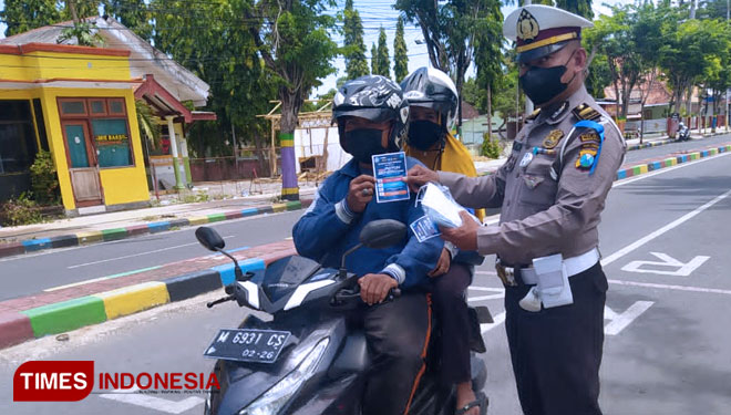 Satlantas Polres Pamekasan saat membagikan brosur Operasi Patuh Semeru 2021 di jalan Kabupaten Pamekasan.(Foto: Akhmad Syafi'i/TIMES Indonesia)