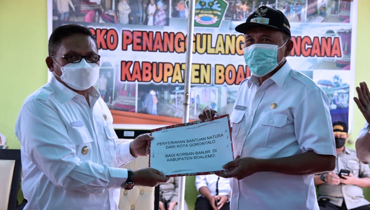 Wali Kota Gorontalo, Marten Taha saat memberikan bantuan kepada masyarakat Boalemo yang diterima langsung oleh Plt. Bupati Boalemo, Anas Jusuf. (FOTO: Humas Pemkot Gorontalo)