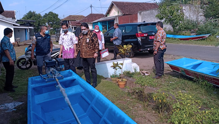 Kepala Dinas Perikanan Kabupaten Malang Victor ketika memberikan bantuan perahu bagi nelayan binaan MUI. (FOTO: Dinas Perikanan Kabupaten Malang).