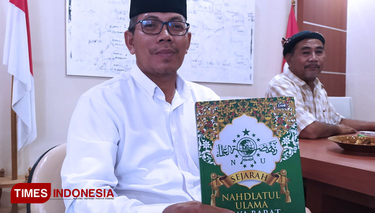 Ketua PCNU Kabupaten Indramayu Juhadi Muhammad, saat menunjukkan buku Sejarah NU Jawa Barat. (Foto: Muhamad Jupri/TIMES Indonesia)