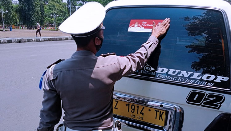 Petugas Polres Ciamis melakukan pemasangan stiker ayo pakai masker kepada kendaraan yang masuk objek wisata Pangandaran (FOTO: Humas Polres Ciamis)