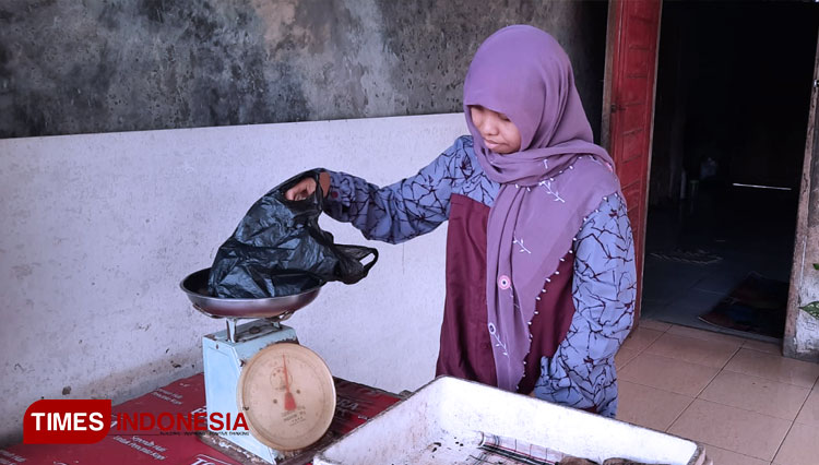 Aas saat menimbang ubi untuk pembelinya (foto: Susi/TIMES Indonesia)