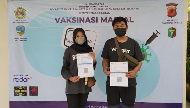 Dua orang peserta berfoto dengan memperlihatkan sertifikat vaksinasi seusai melaksanakan vaksinasi di Kampus SMA Negeri  2, Jalan RE Martadinata, Panyingkiran Indihiang, Kota Tasikmalaya, Sabtu (25/9/21) sore. (FOTO: Humas Polres Tasikmalaya Kota/TIMES In
