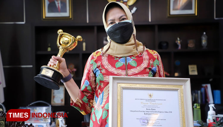 Wali Kota Batu, Dra Hj Dewanti Rumpoko MSi memegang trophy APE Tahun 2020 yang diberikan oleh Kementerian PPPA RI. (Foto: Prokopim for TIMES Indonesia)