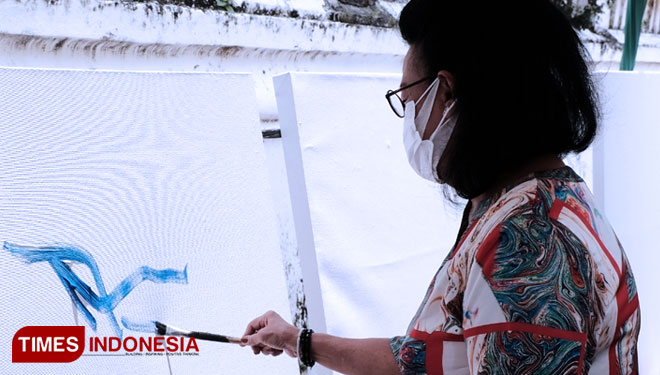 GKR Hemas menggoreskan cat pada kanvas yang akan dilukis oleh para seniman di tengah kegiatan vaksinasi di Sasono Hinggil Kraton Yogyakarta. (FOTO: Soni Haryono/TIMES Indonesia)
