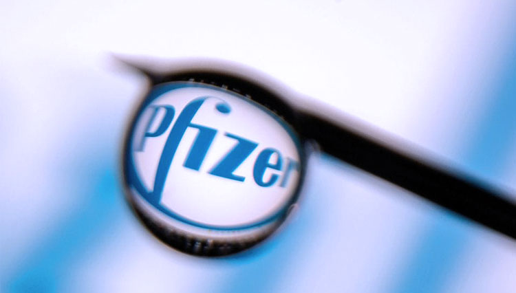 Logo Pfizer tercermin dalam tetesan pada jarum suntik dalam foto ilustrasi ini yang diambil 16 Maret 2021. (FOTO: Reuters)