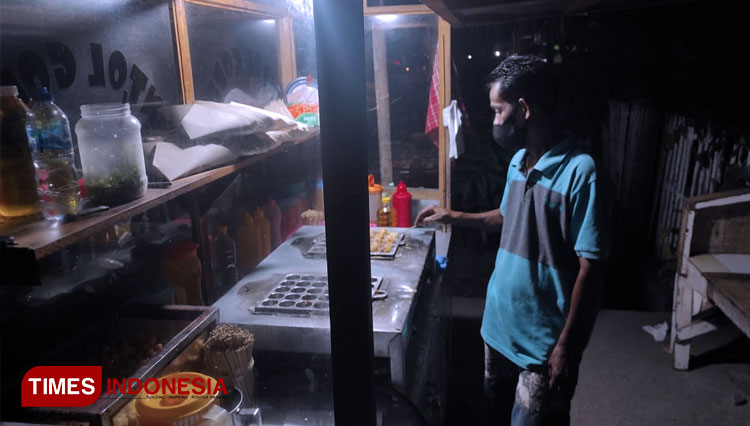 Anden sedang menggoreng pentol yang sedang dipesan pelanggan. (FOTO: Sarjan Lahay/TIMES Indonesia)