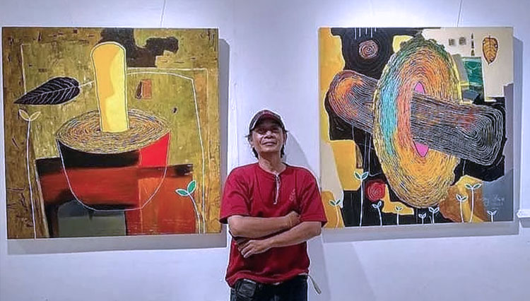 Beni Dewo di antara karya-karyanya yang tampil dalam ajang Art Exhibition Spirit From The East #2 sepanjang 25 September - 2 Oktober 2021 di Gallery Dewan Kesenian Malang (DKM), Kamis (30/9/2021). (FOTO: Dok.Instagram @benidewo_art) 