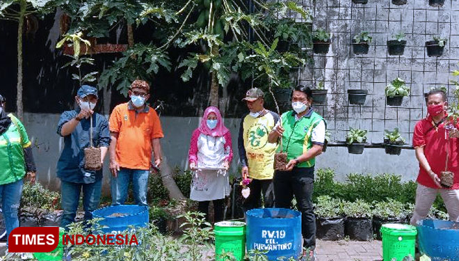 Pihak Alfamart bersama Pembina Kader Lingkungan dan Pembina Wonosari Go Green menunjukkan bibit pohon mangga yang hendak ditanam. (Foto: Naufal Ardiansyah/TIMES Indonesia)