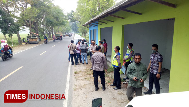 Petugas kepolisian ketika mendatangi lokasi tewasnya Iwan Setiawan kurir salah satu perusahaan ekspedisi di Kabupaten Bangkalan. (FOTO: Doni Heriyanto/TIMES Indonesia)