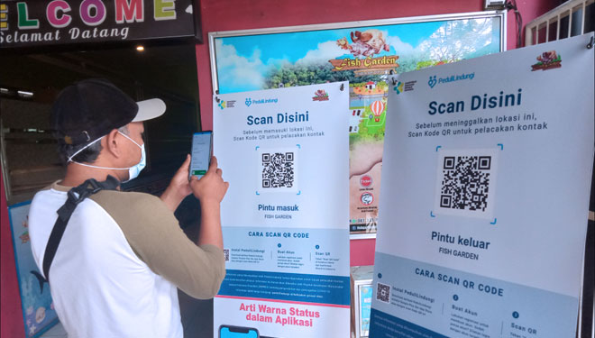 Seorang warga mencoba barcode aplikasi PeduliLindungi di wisata Fish Garden di Jl Bengawan Solo, Kota Blitar, Jumat (8/10/2021). (Foto: M Sholeh/TIMES Indonesia)