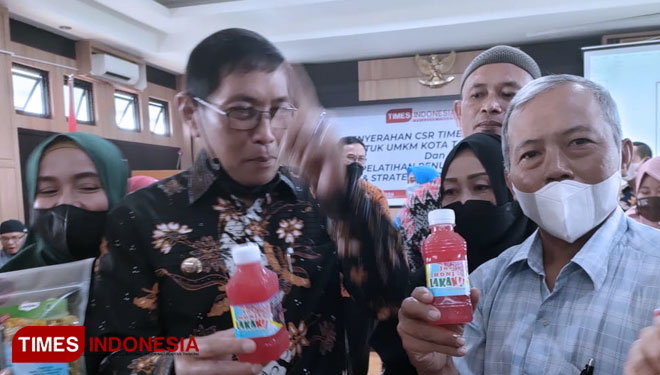 Pelaku UMKM Maman memperlihatkan produk minuman kemasan botol Jus Honje Lakaku saat berfoto bersama Wali Kota Tasikmalaya HM Yusuf di Aula Balai Kota Tasikmalaya. (FOTO: Harniwan Obech/TIMES Indonesia) 