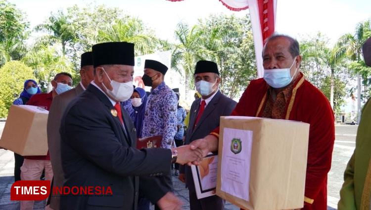Gubernur KH Abdul Gani Kasuba menyerahkan bantuan alat musik tradisional kepada Kepsek SMK Bina Insani Halbar.(foto: Aprillia for TIMES Indonesia)