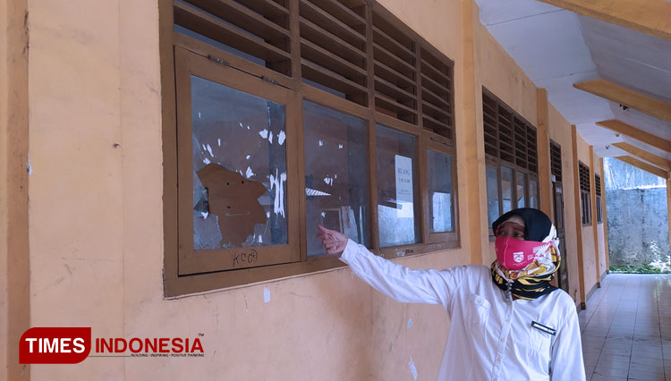 Kepala Sekolah SMP PGRI Sindang Kabupaten Indramayu saat menunjukkan kaca yang pecah akibat lemparan batu.(Foto: Muhamad Jupri/TIMES Indonesia)