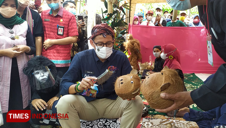 Menteri Sandiaga Uno saat mencoba membuat kepala kethek dari kelapa yang jadi salah satu ikon Desa Cikakak.(FOTO : Sutrisno/TIMES Indonesia)