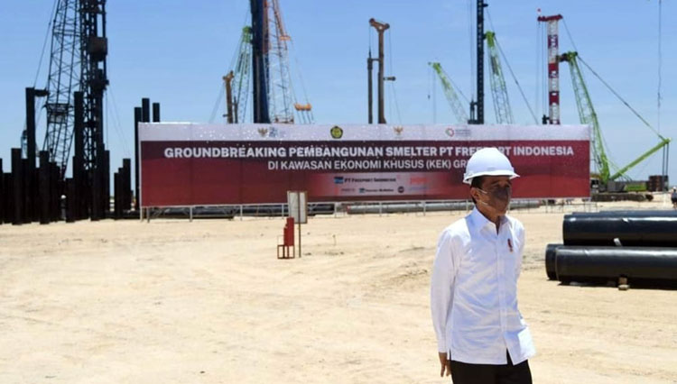 Presiden RI Joko Widodo berdiri dengan latar lokasi pembangunan smelter Freeport di Gresik, Selasa (12/10/2021). (foto: setkab RI)