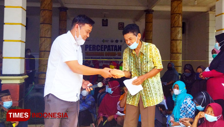  Kades Wonoanti, Agus Riyono membagikan hadiah doorprize kepada warganya yang beruntung dan mengikuti vaksinasi Covid-19 di Balai Desa. (Foto: Yusuf Arifai/TIMES Indonesia). 