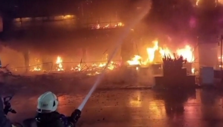 Petugas Pemadam Kebakaran saat berusaha memadamkan api di bagian bawah gedung yang penuh dengan tumpukan barang dan sampah.(FOTO: Screenshot BBC)