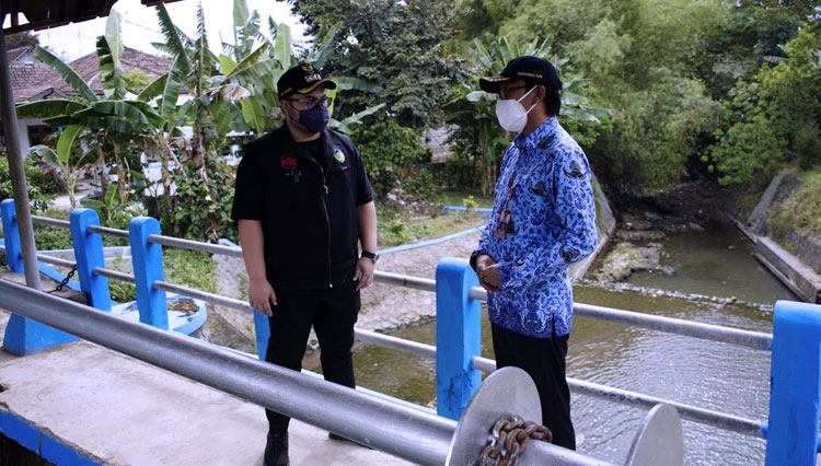 Bupati Kediri dan kepala PUPR Kabupaten Kediri saat berbincang di pintu air. (FOTO: Diskominfo Kabupaten Kediri)