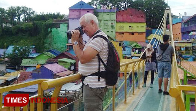 Salah satu wisatawan mancanegara saat mengabadikan gambar di salah satu Kampung Tematik Kota Malang, yakni Kampung Warna-Warni Jodipan (KWJ). (Foto: Dok. Adhitya Hendra/TIMES Indonesia)