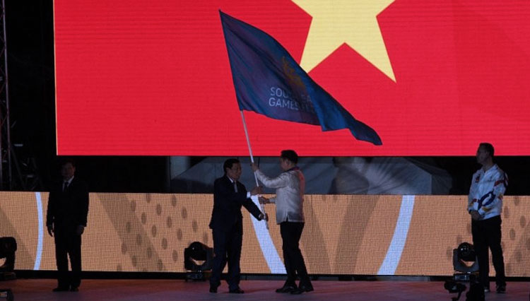 Ketua Komite Olimpiade Filipina Bambol Tolentino (kanan) menyerahkan bendera SEA Games kepada seorang pejabat Vietnam saat penutupan SEA Games di stadion atletik Clark, Utara Manila 11 Desember 2019. (ANTARA/AFP)