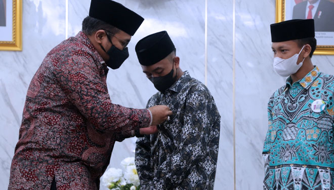 Penyematan pin Menteri Agama dari Yaqut Cholil Qoumas kepada Afi Ahmad Ridho di Ruang Rapat Pimpinan Kemenag RI. (FOTO: Humas for TIMES Indonesia).