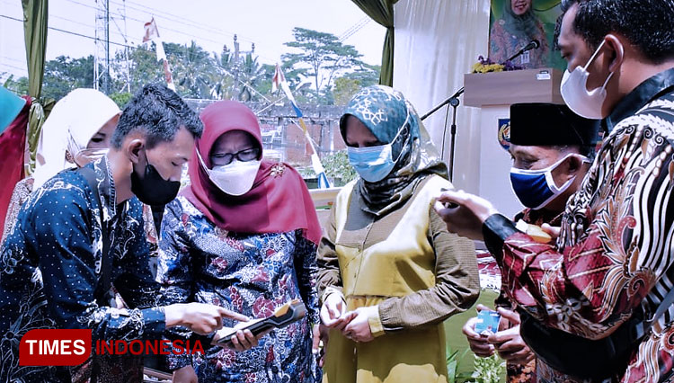 Seorang petugas pasar menunjukkan sistem kerja penarikan retrribusi pasar secara elektronik menggunakan mesin mobile POS kepada Bupati Tegal, Dra H Umi Azizah. (FOTO: Oka Humas Pemkab For Times Indonesia)