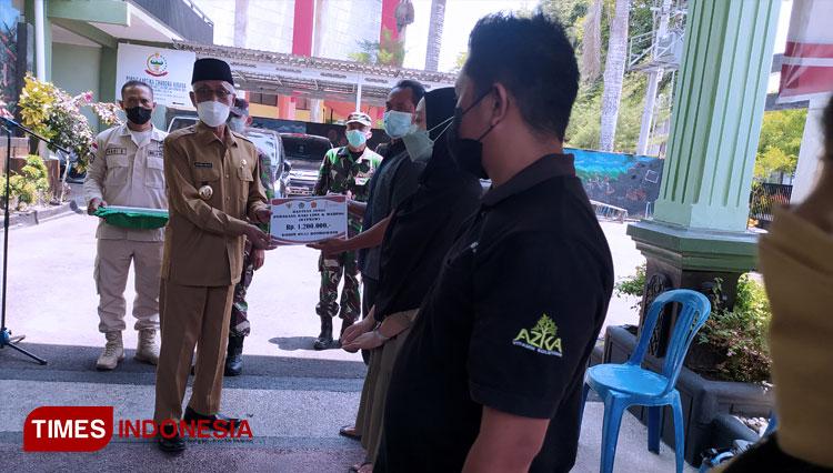 Bupati Bondowoso KH Salwa Arifin saat menyerahkan langsung bantuan kepada sejumlah PKL dan pemilik warung (FOTO: Moh Bahri/TIMES Indonesia).