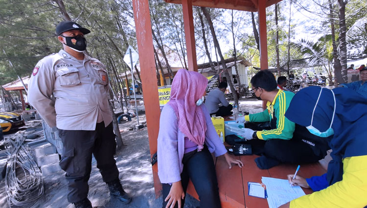 Vaksinator aleng-leng Puskesmas Tongas menyuntikkan vaksin Covid 19 kepada warga (foto: Happy for TIMES Indonesia)