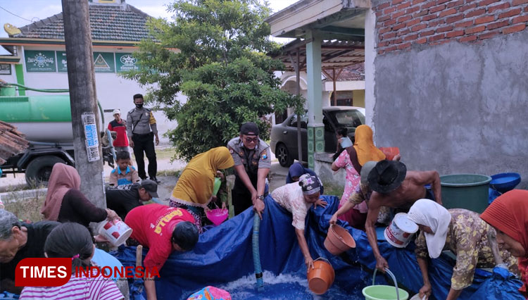 Warga Dusun Kepuh, Desa Kedungkumpu, Kecamatan Sarirejo, mengambil air bersih yang didistribusikan anggota Bhabintamtibmas setempat. (FOTO: MFA Rohmatillah/ TIMES Indonesia)