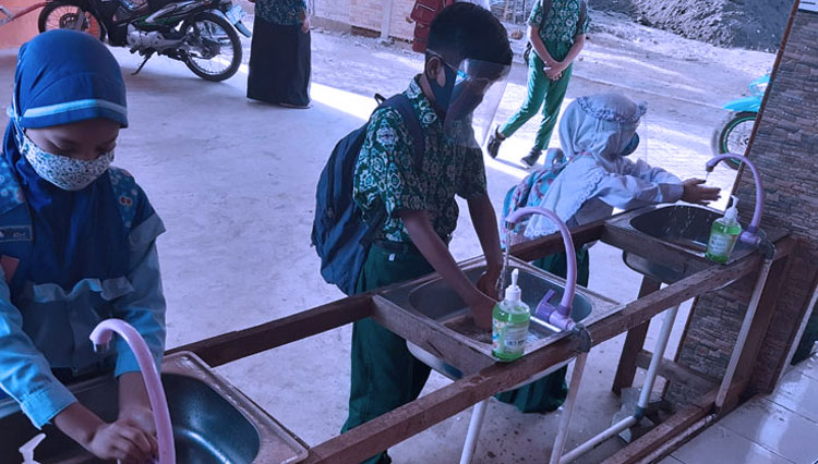 Pelajar di sebuah madrasah di Probolinggo, Jatim, mencuci tangan sebelum masuk ruang kelas (foto: Dokumen)
