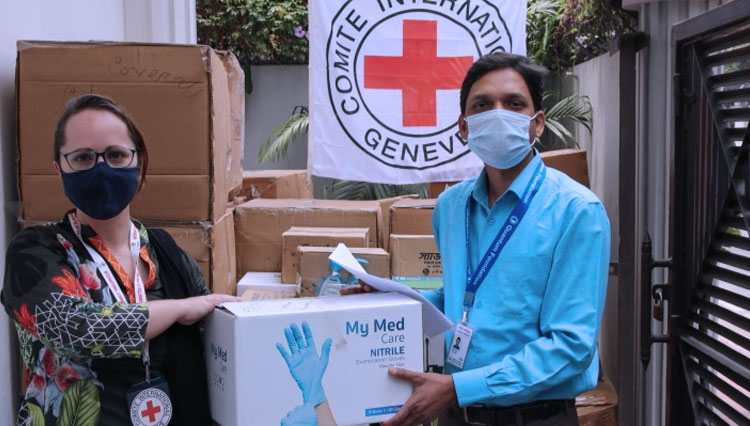 Seorang relawan dari Palang Merah Dunia saat memberikan bantuan kepada masyarakat terdampak pandemi. (foto: Dokumen/Ruters)