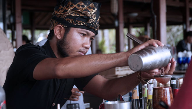 Seorang bartender sedang unjuk kebolehan meracik minuman tradisional Tuak Manis digelaran Festival Pesona Senggigi 2021. (FOTO: Dinas Pariwisata Lombok Barat)